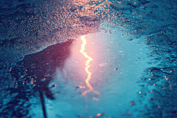 A close up of lightning bolt reflected in puddle, creating stunning visual