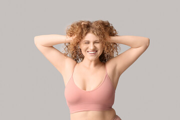 Wall Mural - Beautiful young happy body positive woman in trendy underwear on grey background