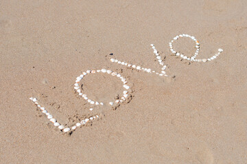 the inscription love on the wet sand of the sea beach in Turkey, lined with white shells, a love message, a declaration of love