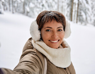 Wall Mural - Smiling Hispanic Woman Winter Portrait in Snow Covered Forest