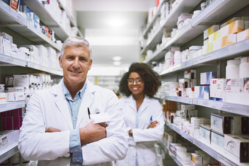 Poster - Portrait, woman and mature man in healthcare, antibiotics and arms crossed for medicine, store and happy to help. Pharmacy, wellness and pharmacist with coworker, smile and quality control in shop