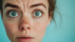© Andres Mejia - Young woman with blue eyes making a shocked face expression