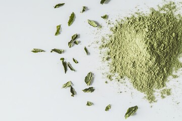 Dried green tea leaves and matcha powder on a white background.