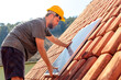 © Marcio - Technician installing a solar panel on a house roof, showcasing renewable energy solutions and sustainable living. Ideal for companies promoting clean energy and solar power installations