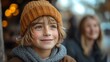 © Thanakan - Young boy with blonde hair wearing a brown beanie smiles and looks up.