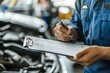 © ASGraphicsB24 - auto mechanic writing on clipboard in auto repair shop. car service concept