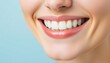 © Sohel - lower half of a face with a beaming smile, featuring perfectly aligned white teeth, set against a gentle blue background that suggests hygiene and freshness.