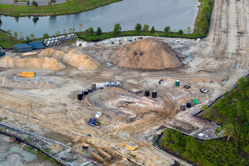 Aerial view of large construction site with building equipment on prepared soil in american rural area. Development of residential housing in US suburbs. Real estate market in the USA