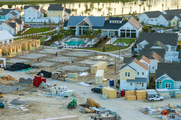 Wall Mural - Unfinished frames of inexpensive homes with wooden roof beams under construction. Development of residential housing in US suburbs. Real estate market in the USA