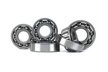 A collection of metal ball bearings in different sizes on a white background