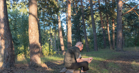 A man is sitting on a log in a forest