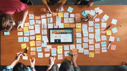 Aerial view of developer team discussing and showing digital program and writing by using Ux Ui design. Top down view of business people develop wireframe prototype for phone and computer. Symposium.