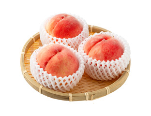 Peaches arranged in a colander on a white background.