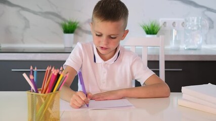 Wall Mural -  An unhappy tired schoolboy boy is doing his homework among stack of books and clutter on his desk. Education, school, learning disability, reading difficulties.