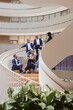 © Johnér - Group of multiracial corporate colleagues discussing on spiral steps in office