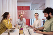 © Johnér - Cheerful corporate employees planning while sitting over table in office