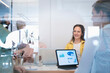 © Johnér - Smiling businesswoman sitting with colleagues in meeting room seen through glass