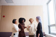 © Johnér - Happy male and female business professionals laughing while talking to each other at office