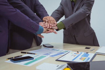 Wall Mural - Close-up of business people shaking hands during a meeting in the office, discussing and analyzing charts,financial data,planning digital marketing projects together with business experts investors