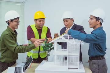 A male engineer and  contractor at a desk in an office discuss the structural design of a house,roof drafting, lot size and number of occupants for a dream home project,focusing on budget and style