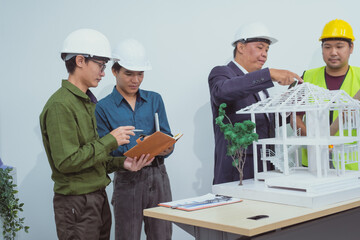 A male engineer and  contractor at a desk in an office discuss the structural design of a house,roof drafting, lot size and number of occupants for a dream home project,focusing on budget and style