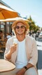 © Food and drink - A blonde man enjoying a scoop of creamy ice cream at a trendy outdoor café.