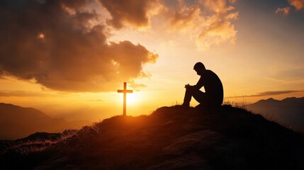 A silhouette of a person praying beside a cross during a stunning sunset, symbolizing hope, faith, and spirituality.