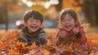 © IMAGINIAC - Two Children Laughing in a Pile of Autumn Leaves