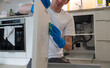 © AnastasiiaAkh - Man cleaning kitchen cabinet with sponge in kitchen room