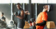 © peopleimages.com - Man, nerd and weak with dumbbell in gym with start to training, fitness and funny at bodybuilding class. People, weightlifting and comic challenge with exercise, health and workout at wellness club