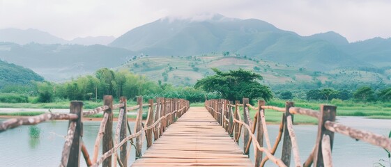 A long wooden bridge stretches over a tranquil body of water, leading towards lush green hills and mountains, creating a picturesque and serene landscape.