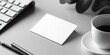 © nurionstudio - Blank white card mockup on a gray table with a cup of coffee, two pens, and a keyboard in the background.