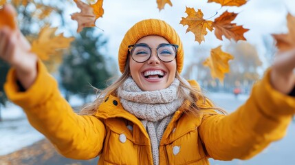 An image capturing the joy of autumn as a person dressed in a yellow jacket and hat playfully interacts with falling leaves, symbolizing the delight and beauty of the fall season outdoors.