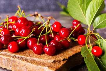 Poster - Fresh sour cherries and green leaves on the board.