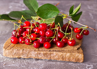 Poster - Fresh sour cherries and green leaves on the board.