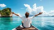 © Pinklife - A man sits on a boat with his arms open wide, embracing the stunning view of a crystal-clear blue ocean, with mountains and sky creating a sense of freedom and adventure.