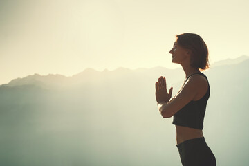 Wall Mural - Young woman is meditating in mountains.