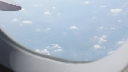 Wall Mural - Looking at the sky through an airplane window while flight flying trip travel above clear blue sky with beautiful cloud,looking at view through window of plane 