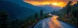 © VeloonaP - A stunning sunset over a winding scenic mountain road surrounded by lush pine trees and misty hills creating a tranquil, picturesque view.