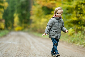 Canvas Print - Cute little boy playing outdoors on sunny autumn day. Child exploring nature. Fall activities for kids.