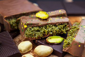 Dubai Chocolate bar with green kadayif and pistachio spread with pistachio nuts close up