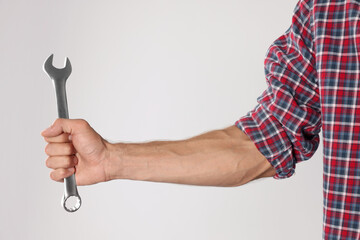 Wall Mural - Auto mechanic with wrench on light grey background, closeup