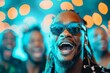 © Zireael - Joyful African Man Celebrating with Friends at Festive Party with Blue Lights