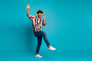 Poster - Full length photo of funky cool guy dressed striped shirt earphones having fun emtpy space isolated blue color background