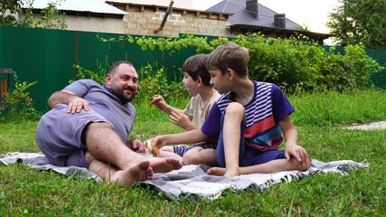 Wall Mural - Father and sons have picnic on the backyard, have fun and time together