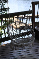 Poster - A small white bird perches on a white fishing net suspended from a tree branch