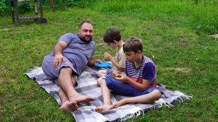 Wall Mural - Father and sons have picnic on the backyard, have fun and time together