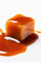 Poster - A single piece of caramel sits on a white surface, perfect for photography or design use