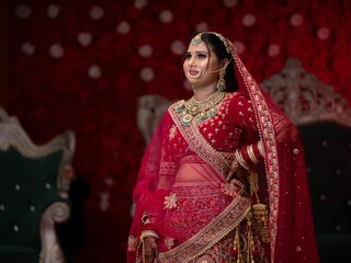 A beautiful Indian bride in a traditional red bridal lehenga.