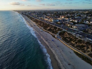 Poster - Aerial view of coastal city and beach at sunset.